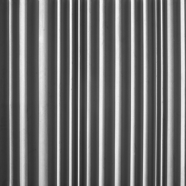 Concrete wall texture with smooth, rounded vertical ribs in a more regular pattern.
