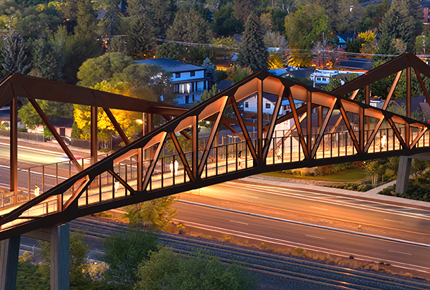 Rendering of the bridge at dusk, with lights glowing along the peaked truss. 